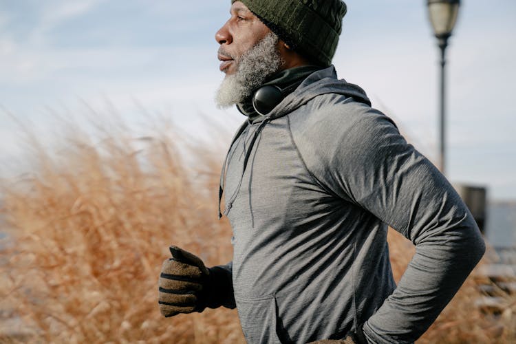 Black Man In Sportswear Jogging In Sunny Autumn Day