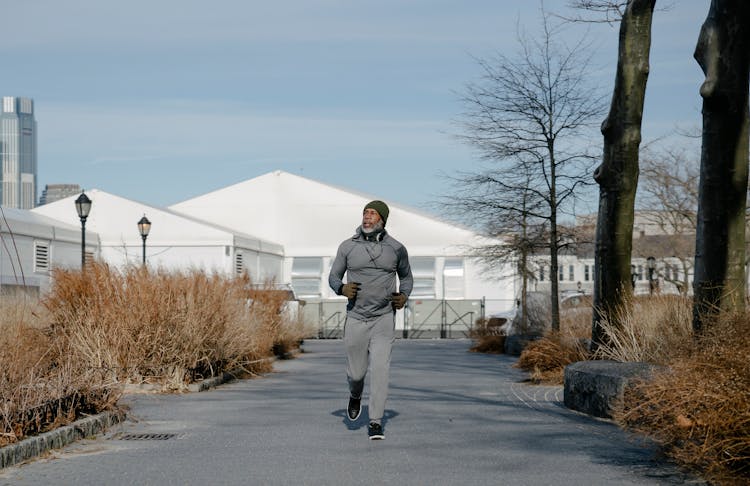 Black Senior Man Running In Park In Autumn Morning