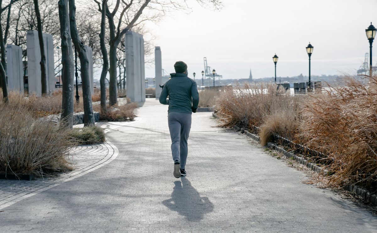 Runner wearing warm functional activewear in an outdoor park