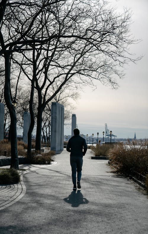 Free Unrecognizable man jogging in park in autumn day Stock Photo