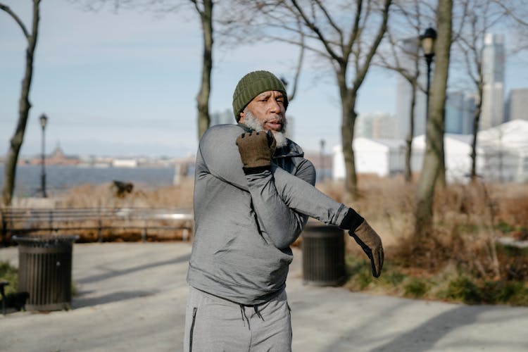 Senior Black Man Stretching Arm While Doing Morning Exercise Outdoors