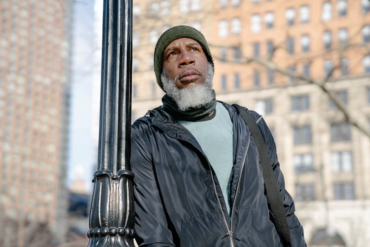 African American Male Thinking Near Post In Autumn