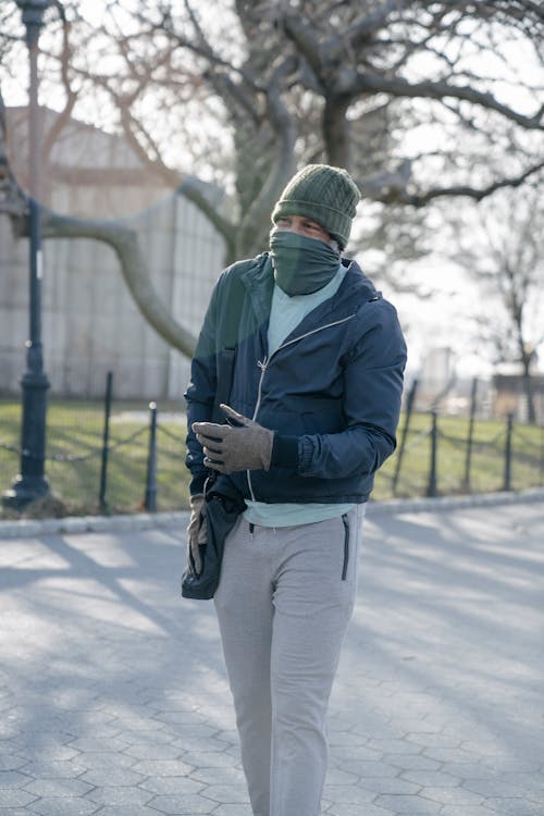 Male walking with scarf on face in fall