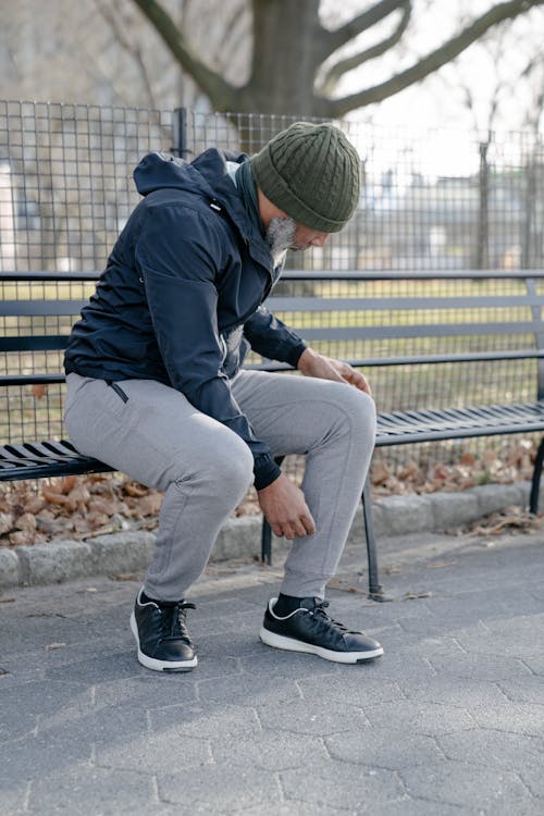 Man Sitting on Black Metal Bench Under the sun · Free Stock Photo