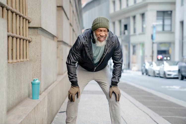 Senior Black Man In Casual Outfit Standing On Street