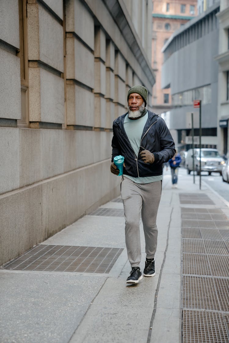 Stylish Senior Black Man Running On Pavement In Street