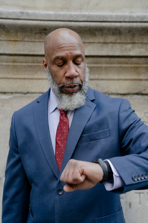 Senior businessman in formal suit looking at wristwatch