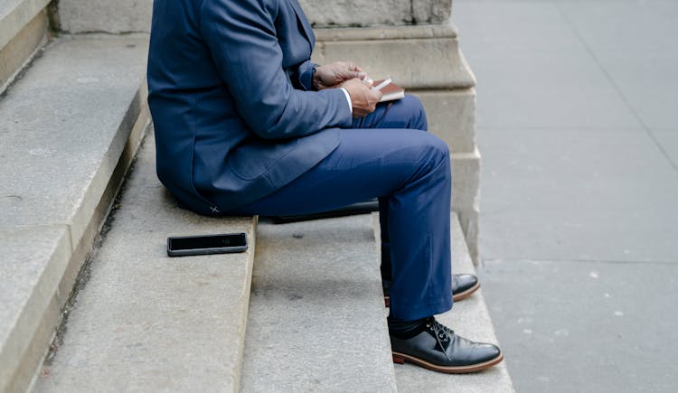 A Person In A Suit Sitting On Stair Steps