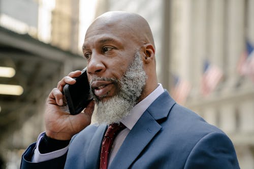 Free Man in Blue Suit Holding Black Smartphone Stock Photo