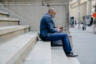Man in Blue Suit Jacket and Blue Pants Sitting on Concrete Bench