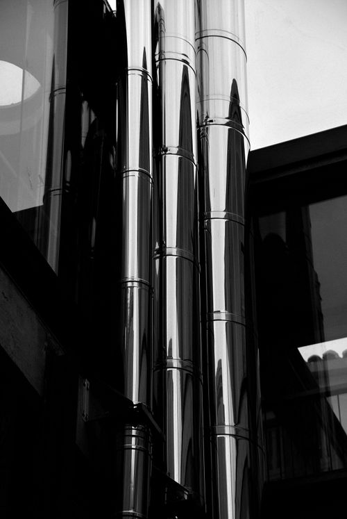 Free Black and white shot highlighting the modern shine of chrome pipes in urban setting. Stock Photo