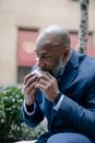 Man in Blue Suit Eating a Sandwich