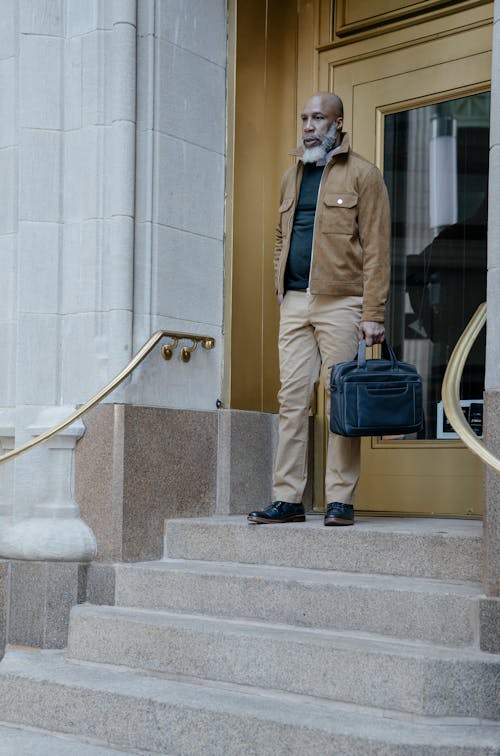 Man wearing Brown Jacket holding a Bag 