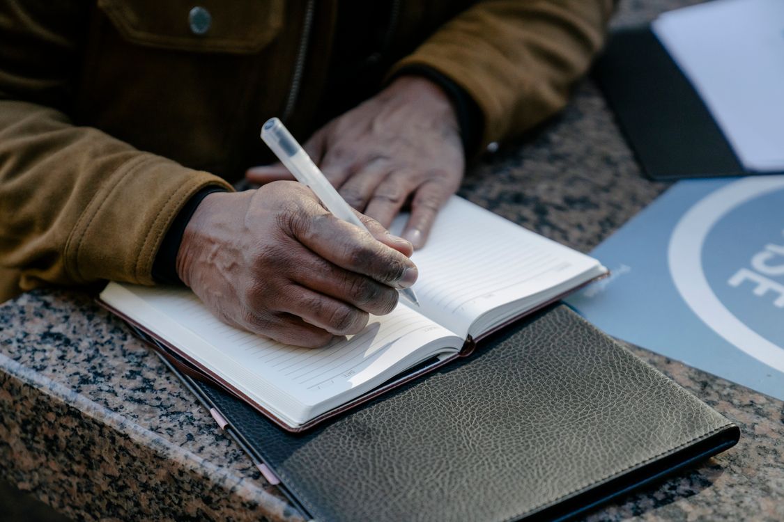 Person Writing in Notebook · Free Stock Photo