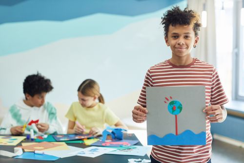 Free Children creating art projects in a classroom setting, showcasing creativity and teamwork. Stock Photo