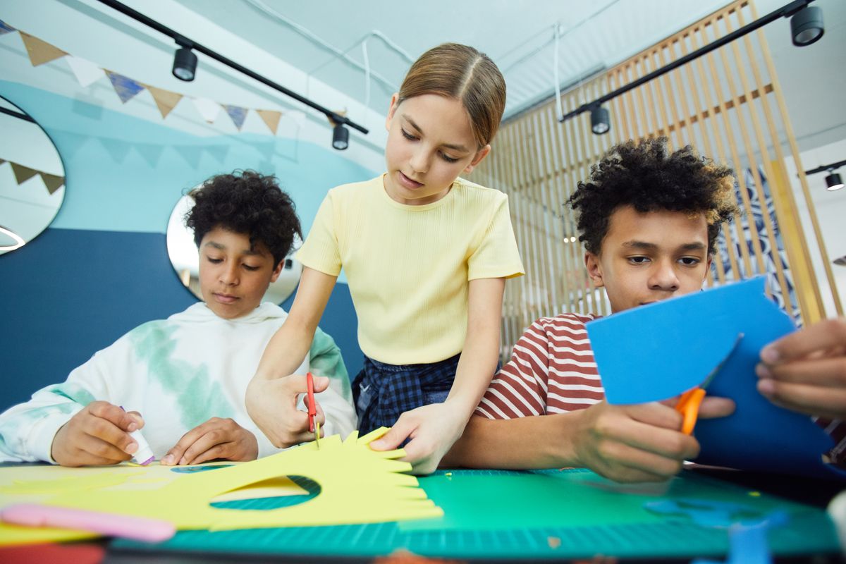 Child using scissors for paper plate crafts for kids