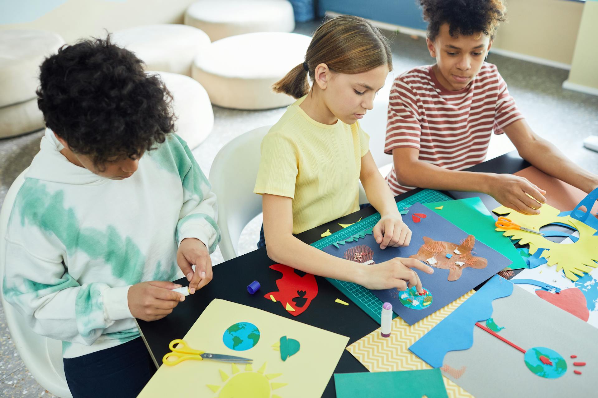Children engaging in a creative crafting session with colorful art materials at a workshop table.