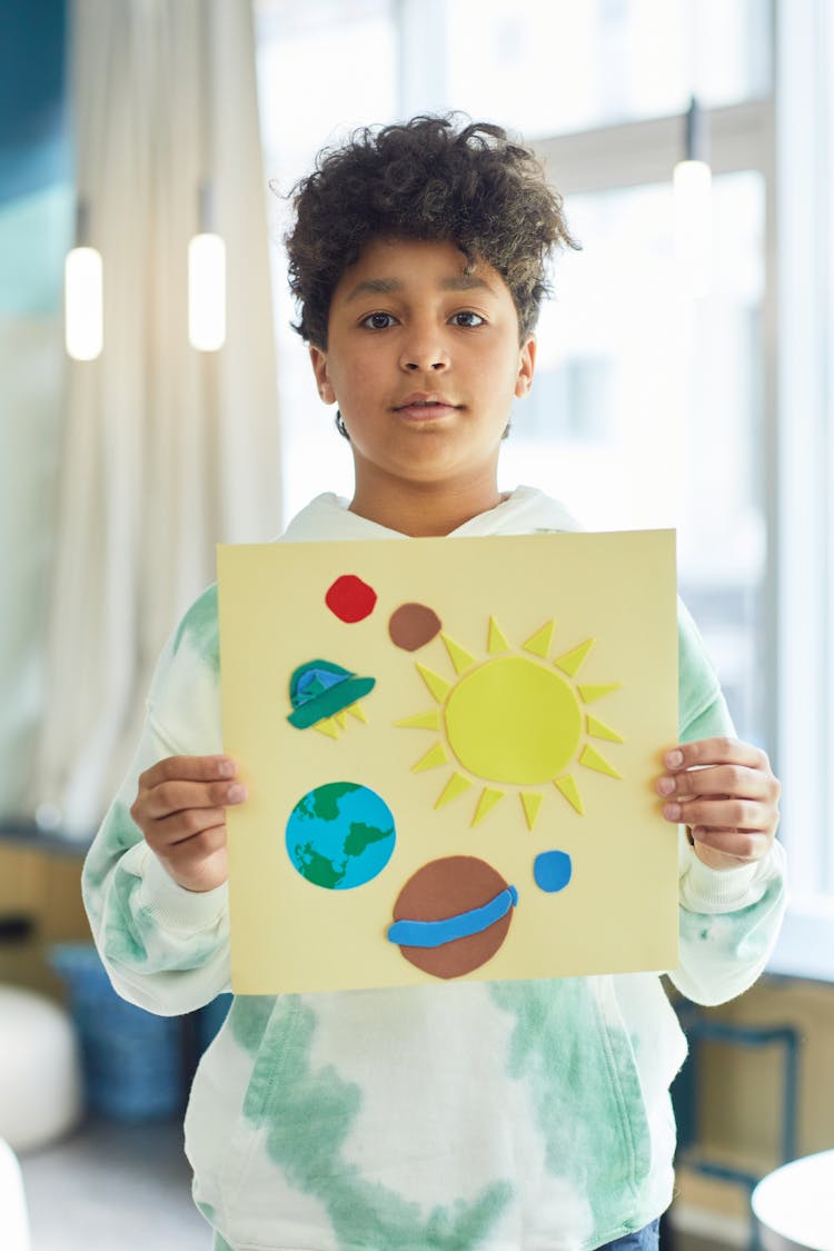 A Boy Holding His Art Project