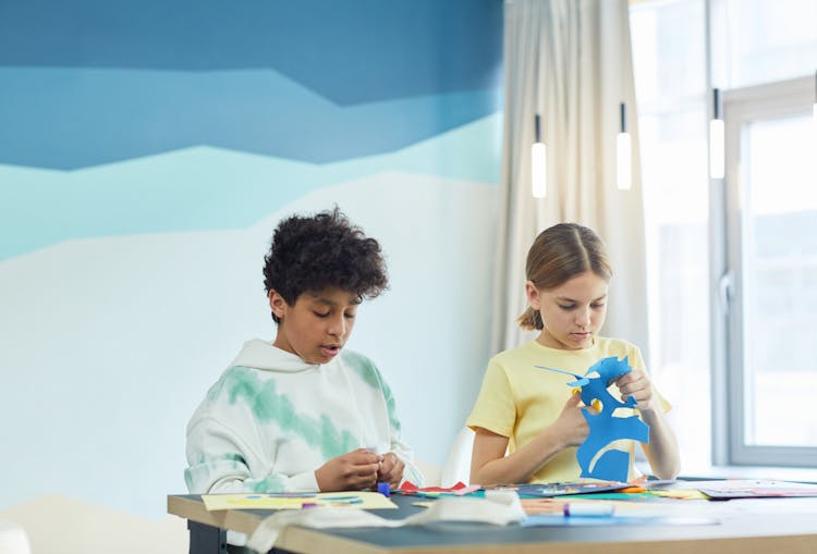 Boy And Girl Cutting Colored Paper