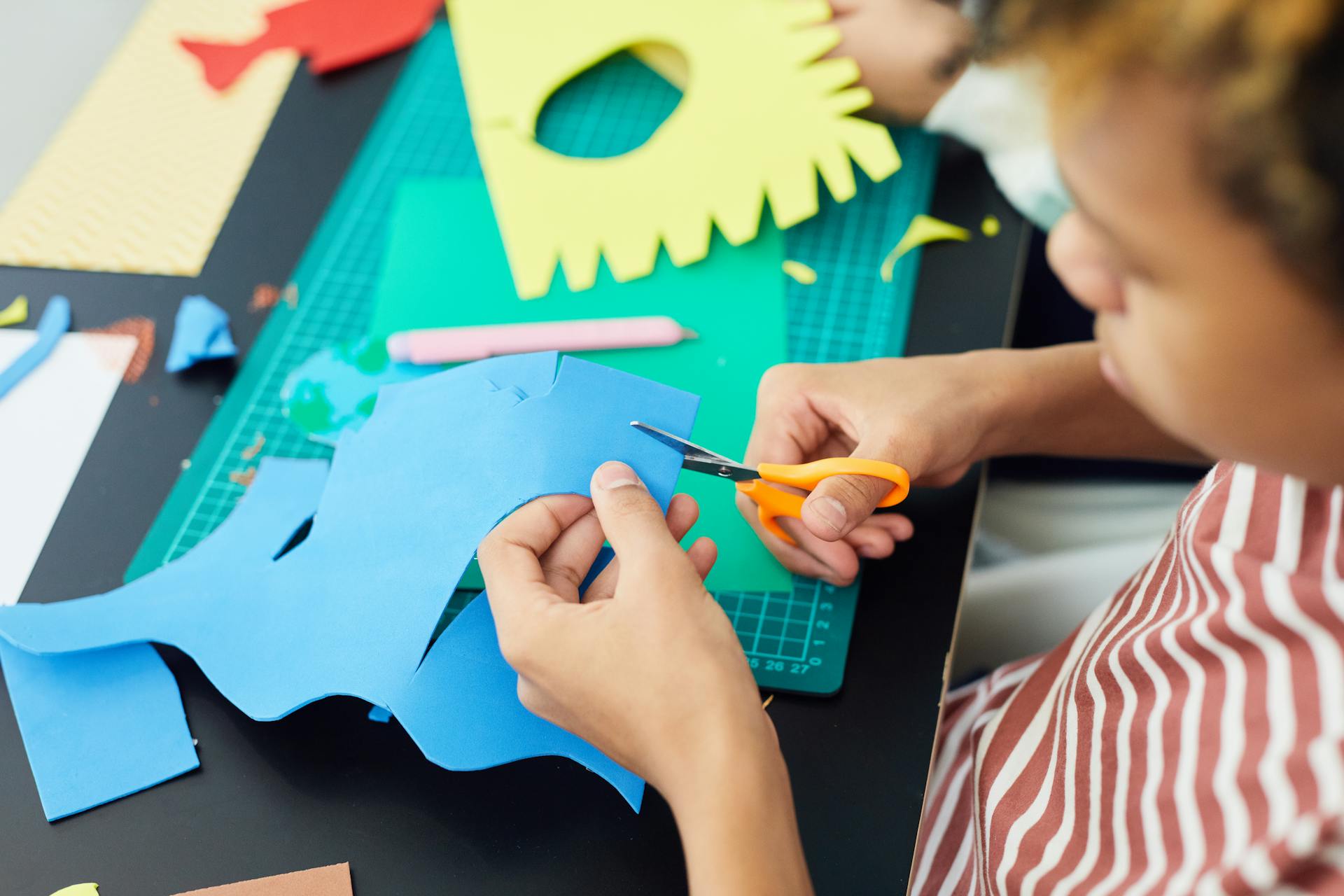 A Boy Cutting a Paper