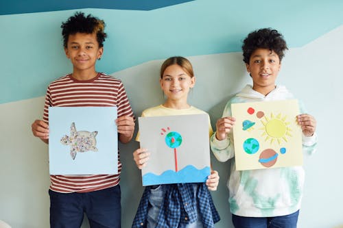 Young Students Holding their Art Projects