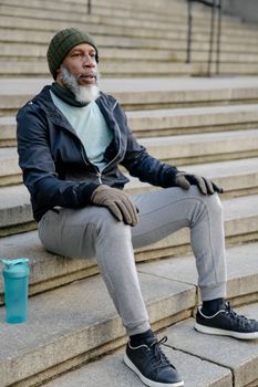 Mature Mam with a Gray Beard Sitting on Stairs After Running Outdoors 