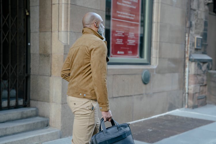 Man In Beige Jacket Walking With A Briefcase On Street