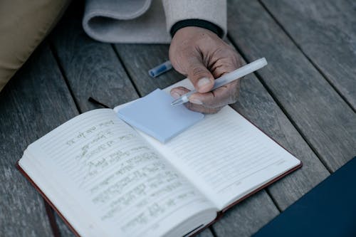 Person Writing on a Sticky Note