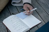 Person Holding Pen and Book