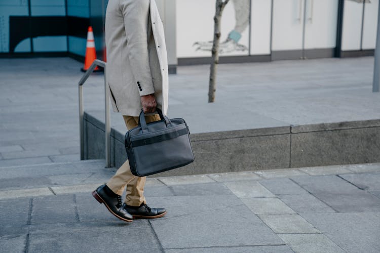 A Person Carrying A Bag While Walking 