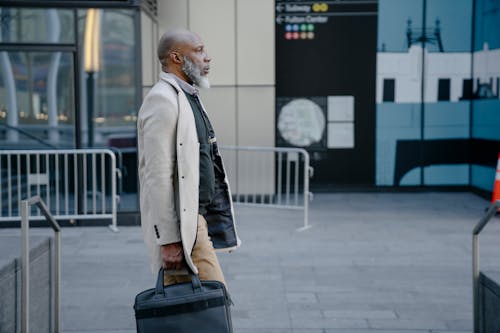 A Man Walking While Carrying Handbag