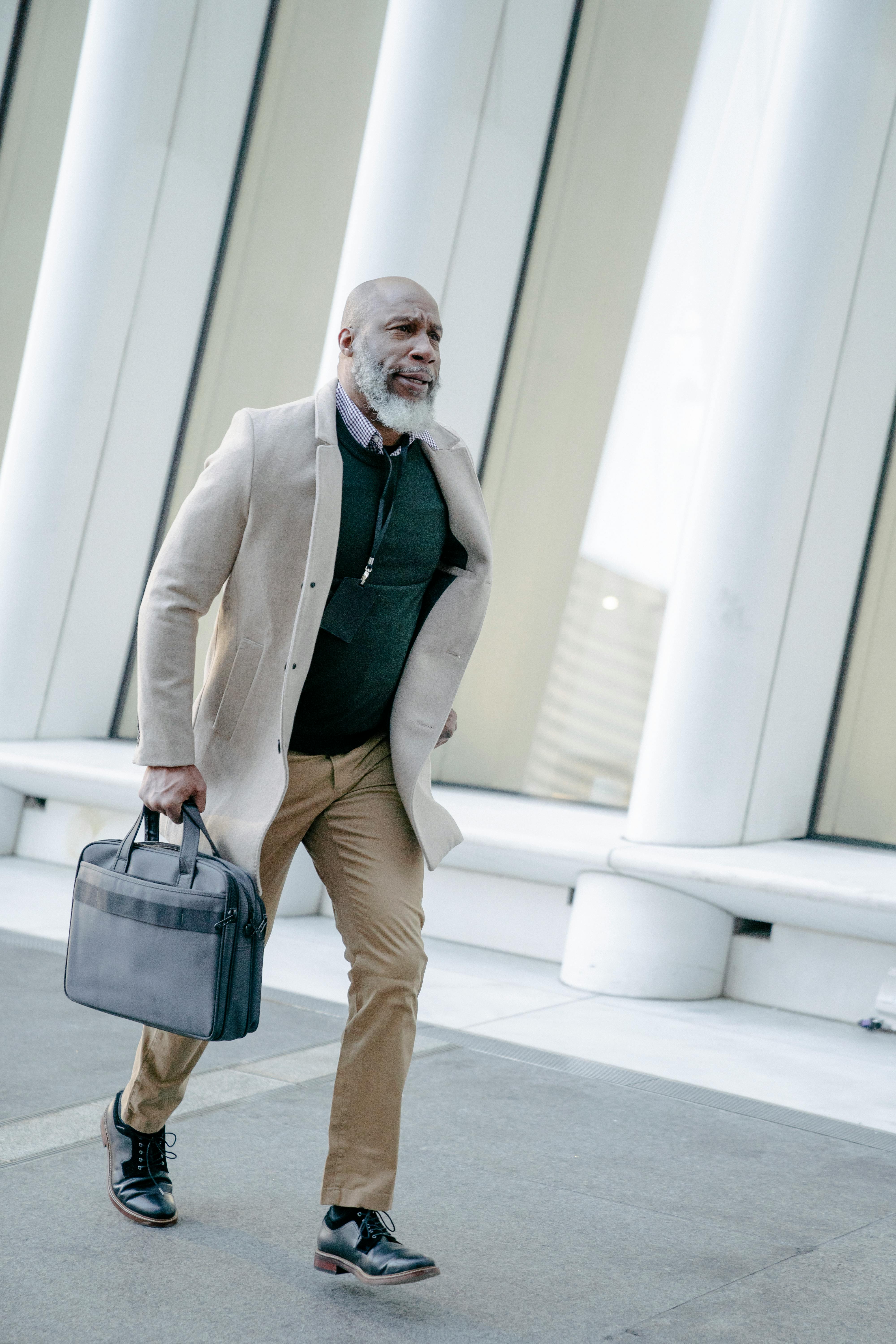 A Man in Brown Jacket and Beige Pants Holding a Leather Briefcase  Free  Stock Photo