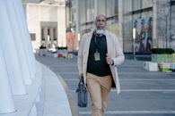 A Man in a Trench Coat Holding a Handbag Running