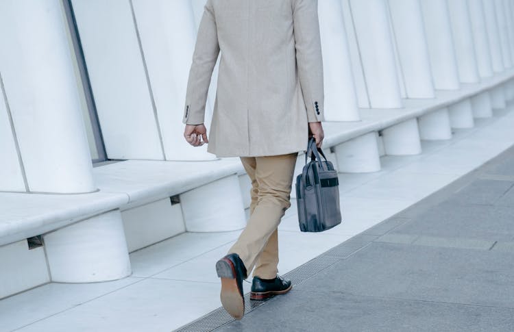 Back View Of An Elegant Man Walking With A Briefcase 