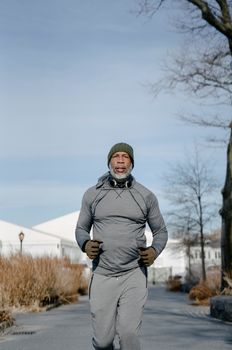 Mature Man with a Gray Beard Running in City 