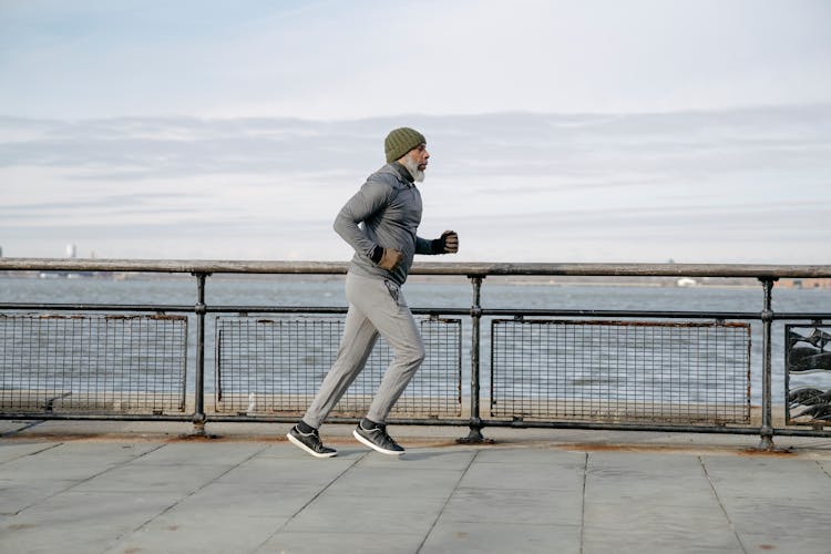 An Elderly Man Running Beside The Beach