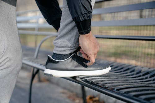 Free A Person Tying his Black and White Sneaker Shoes Stock Photo