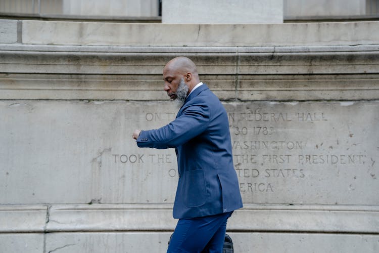 A Man In A Suit Checking The Time