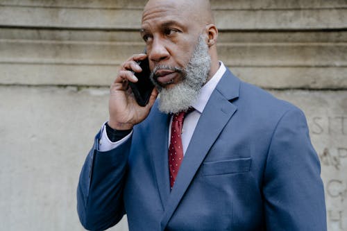 Free Man Wearing a Blue Suit Talking on the Phone Stock Photo