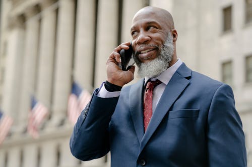 Man in Blue Suit Using Cellphone