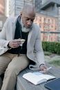 Man Eating a Sandwich While Writing