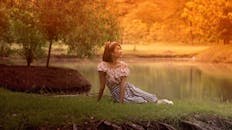 日落时分，一位年轻女子在风景优美的湖边享受宁静时光