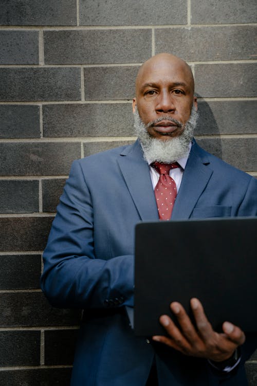 Free Man in Blue Suit Jacket Holding a Laptop Computer Stock Photo
