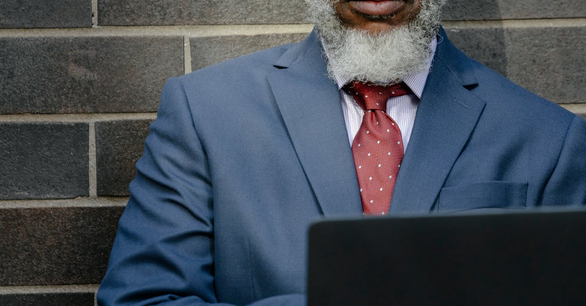 Man in Blue Suit Jacket Holding a Laptop Computer · Free Stock Photo