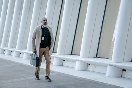 Man in Corporate Attire Holding a Black Handbag