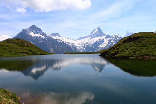 Lake in the Middle of Green and Snowy Mountains