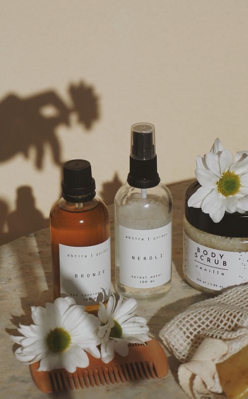 Free Aesthetic arrangement of body care products with daisies, sunlight, and shadows. Stock Photo
