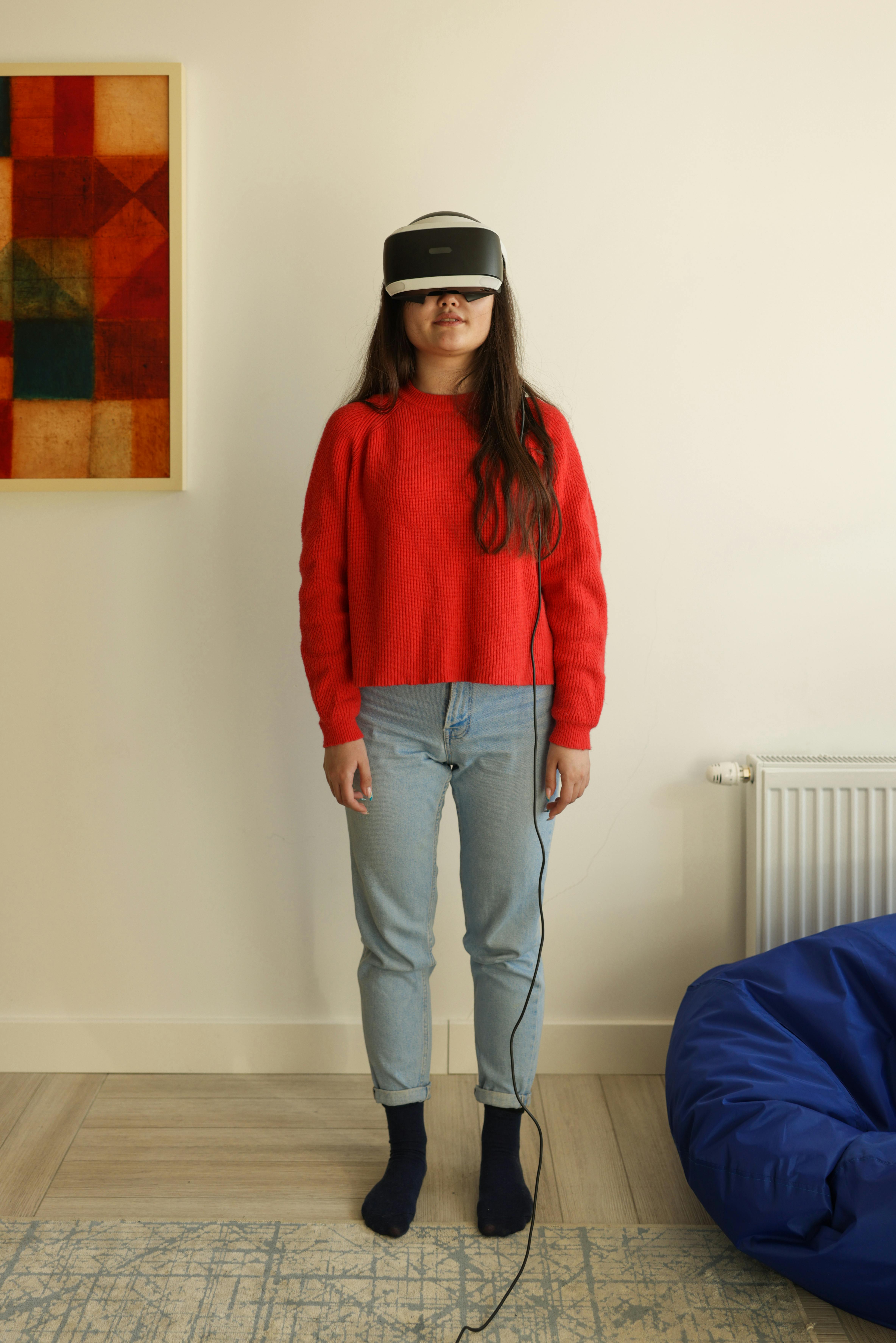 a woman in red sweater wearing virtual reality