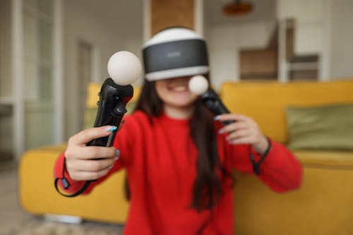 Person in Red Sweater Holding VR Controllers