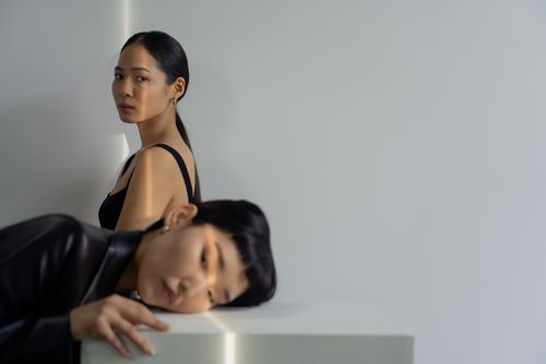 Free Introspective scene of two women indoors with soft lighting and minimalist style. Stock Photo